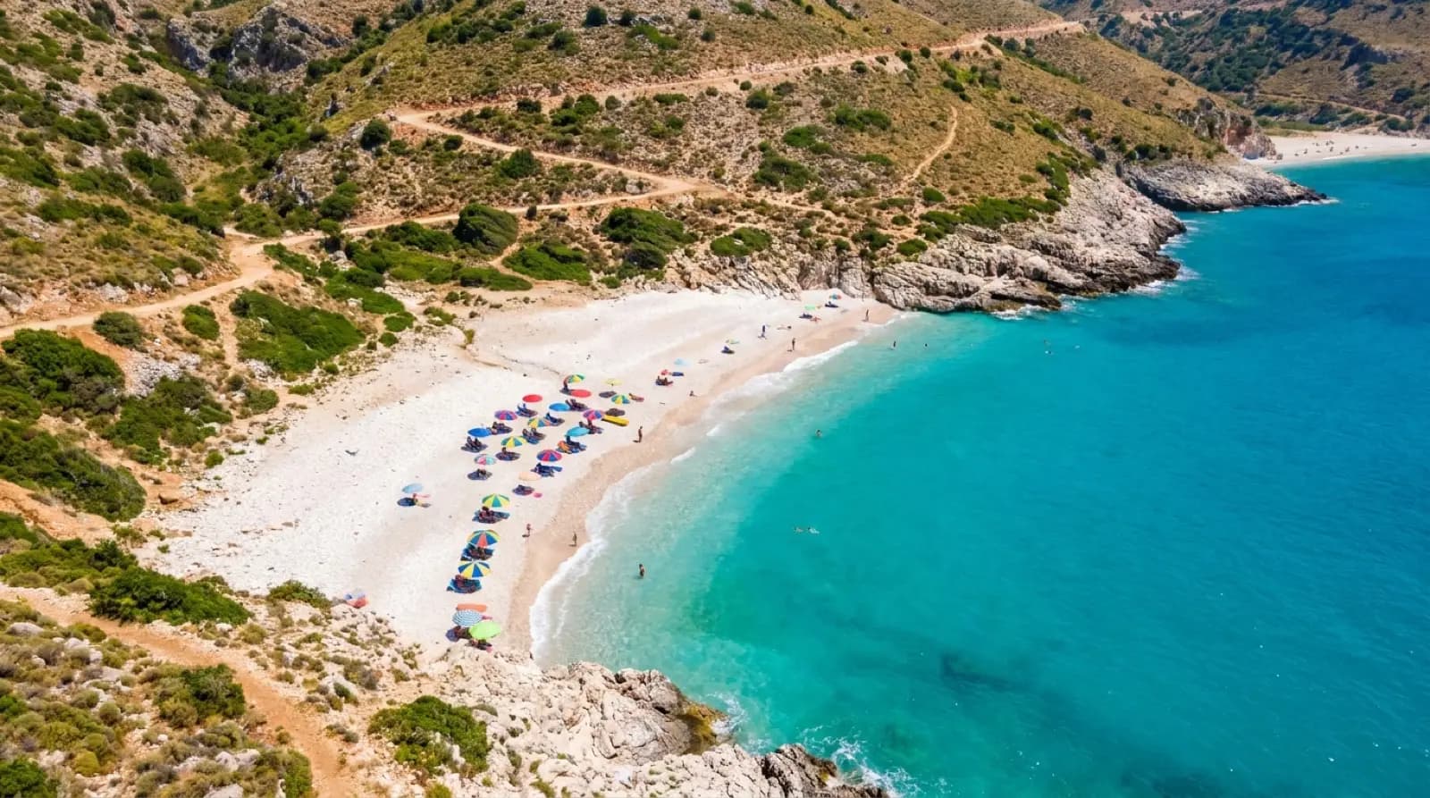 Turquoise bay with white pebble beach on the Albanian Riviera seen from above